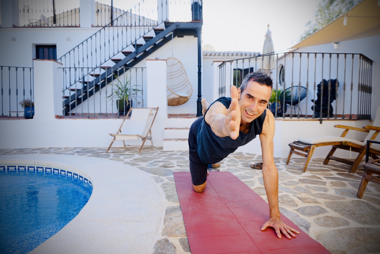 Yogadocent Joost begeleidt een hatha yogales in Andalusië aan het zwembad