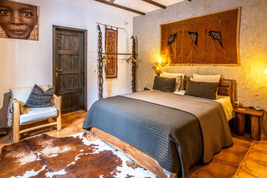 ample bedroom with comfy matress and african decoration