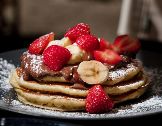 Heerlijk versgebakken pannenkoek met aardbeien en chocolade